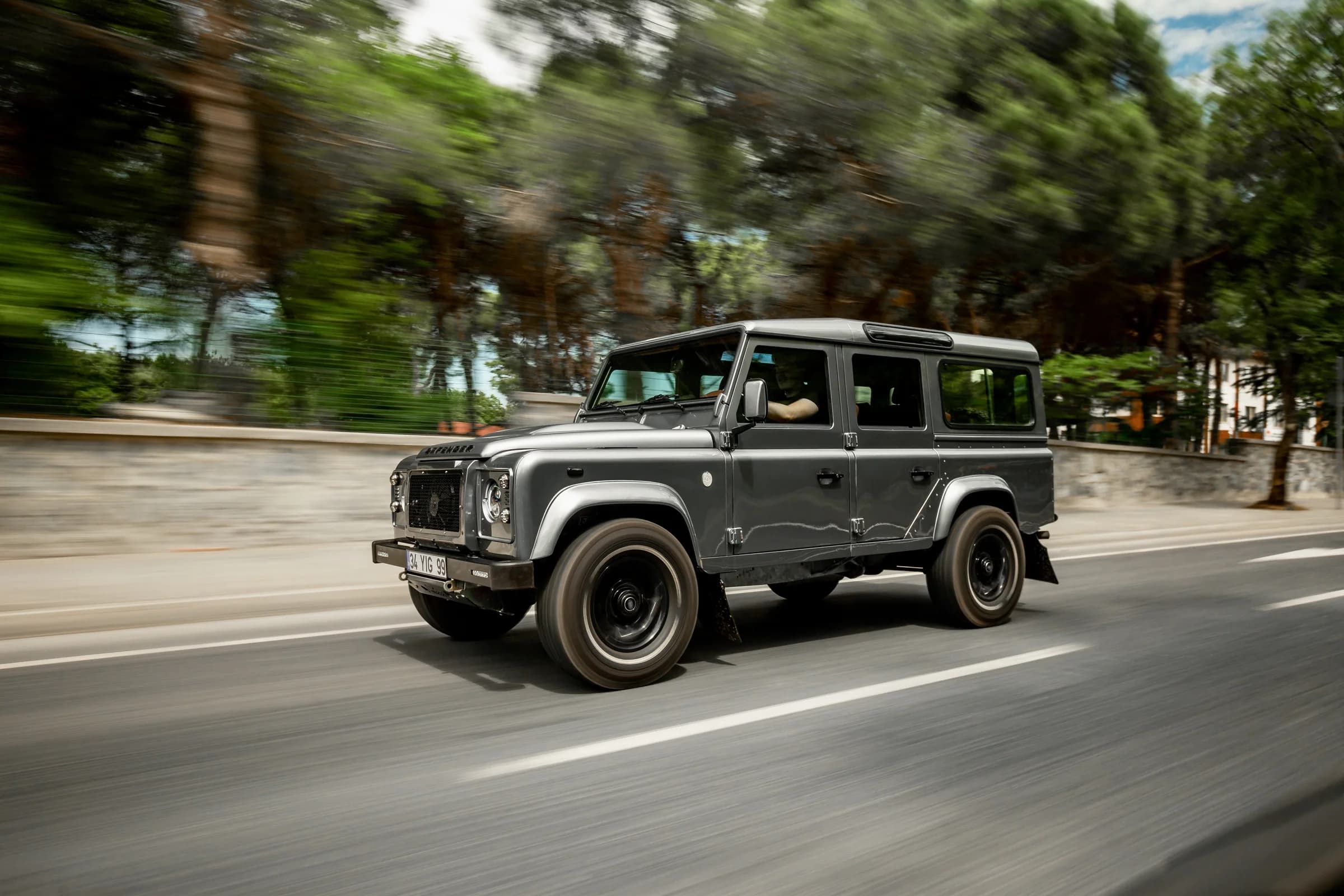 Altera Defender crew cab driving through a forest